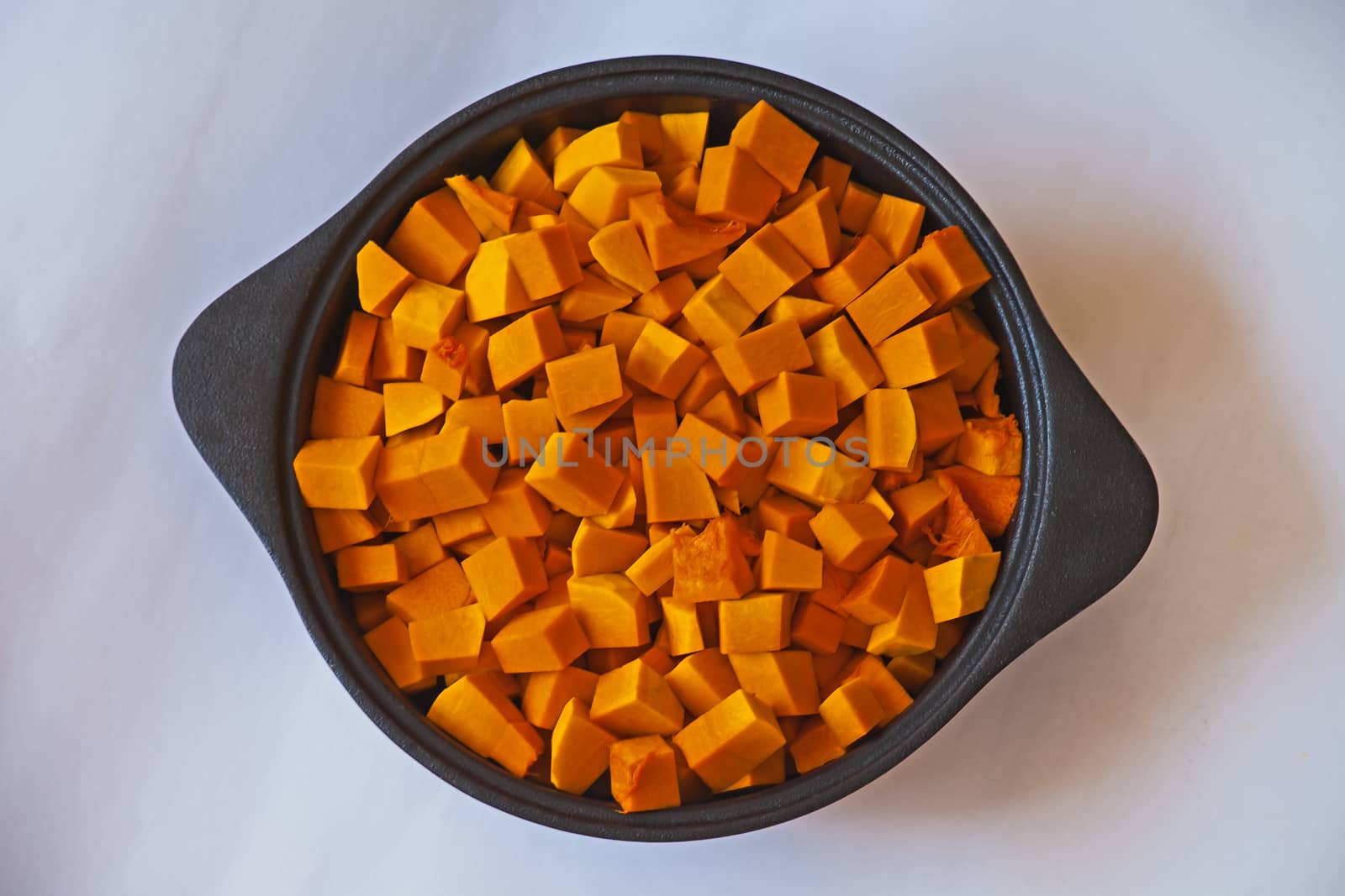 Pumpkin squares in a cast iron pot ready to be cooked.