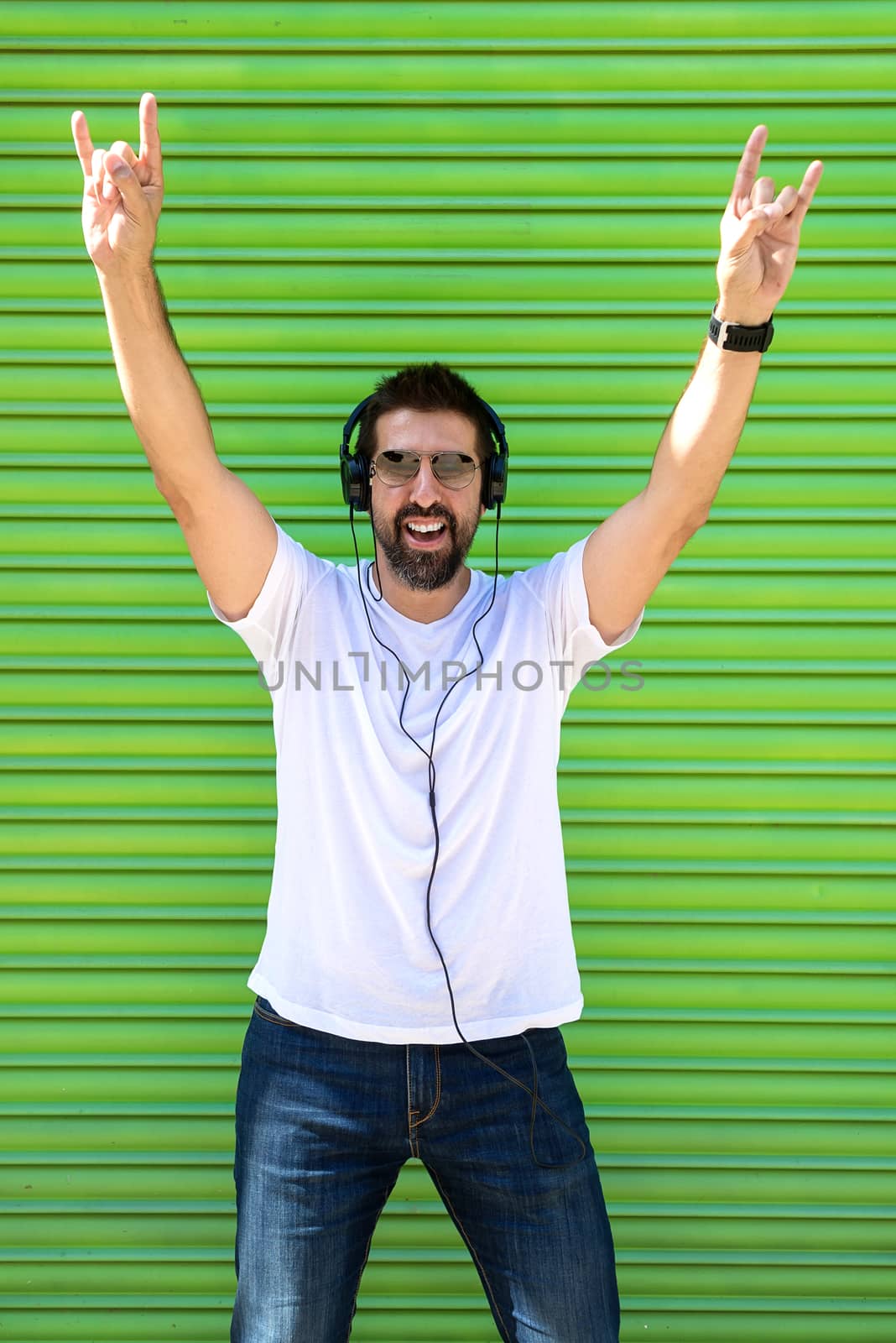 Cool trendy funny beard man in headphones listening music on colored background. by raferto1973