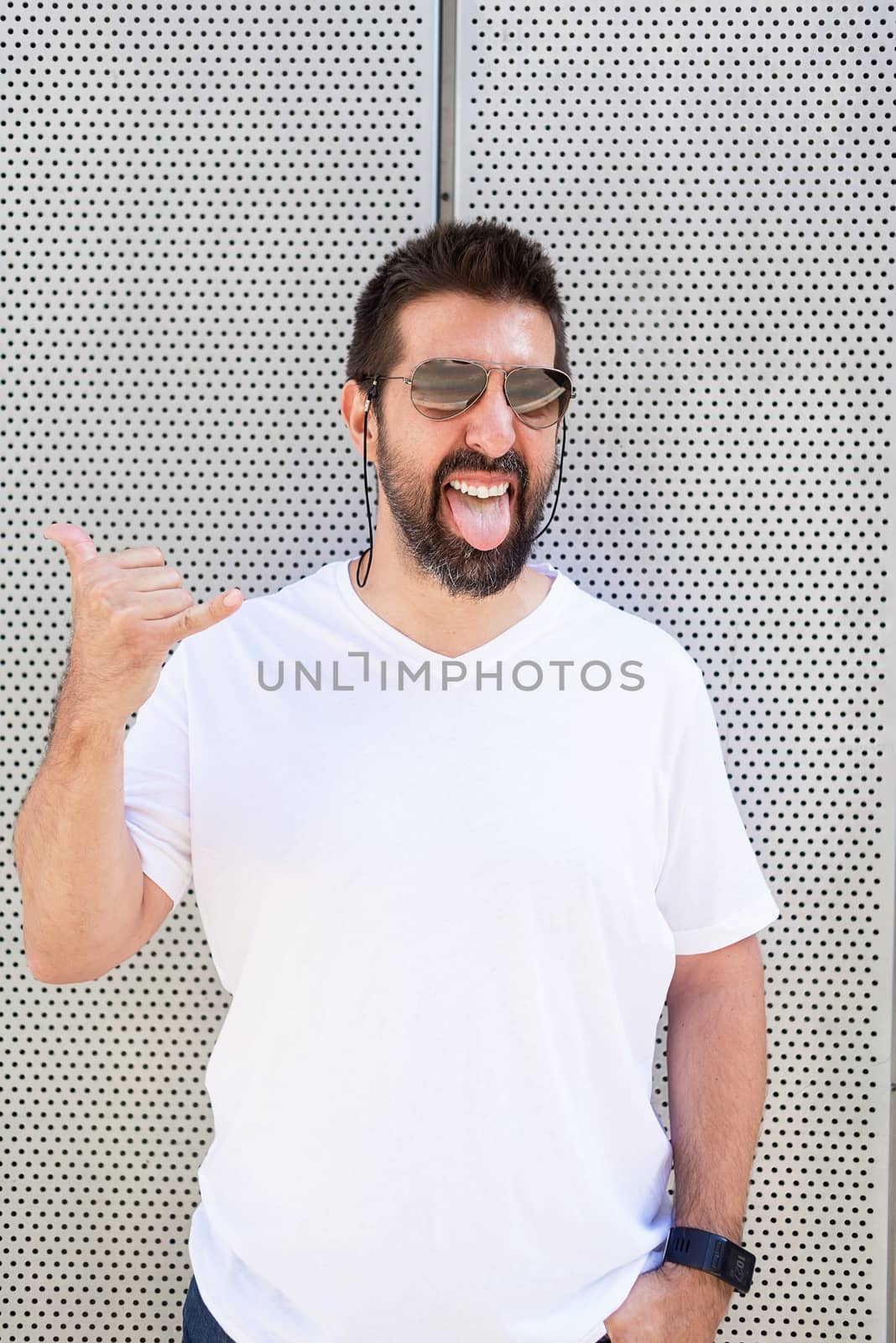 Bearded man with sunglasses gesturing while looking at camera