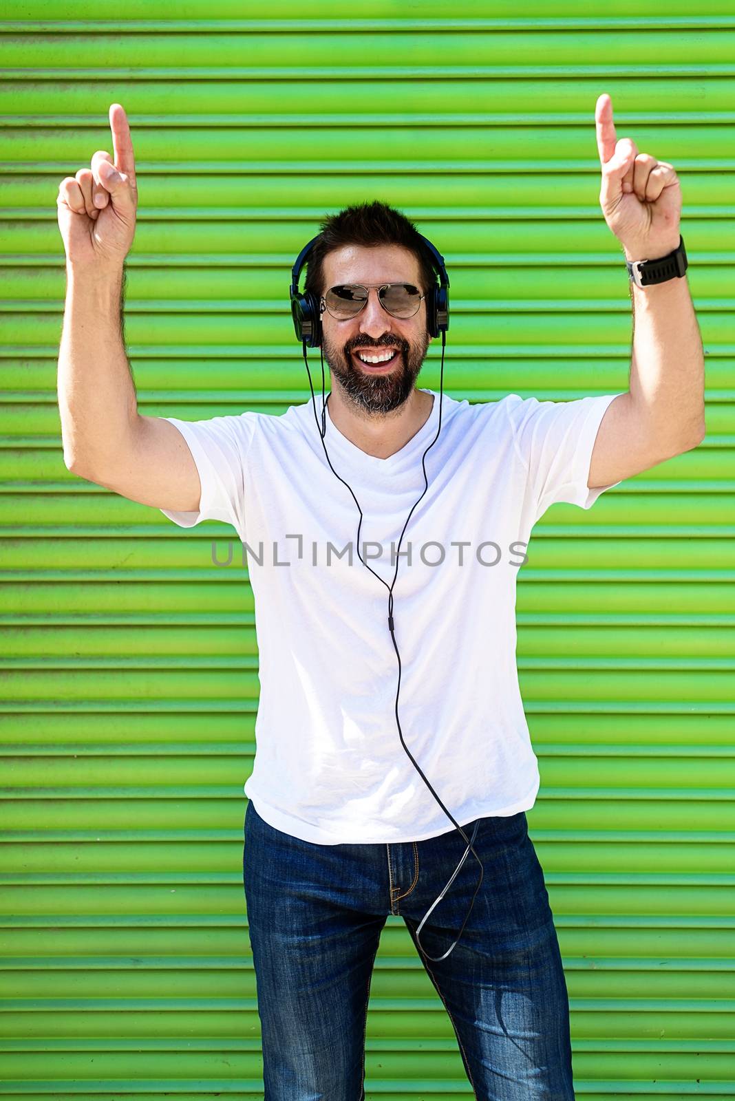 Cool trendy funny beard man in headphones listening music on colored background. by raferto1973