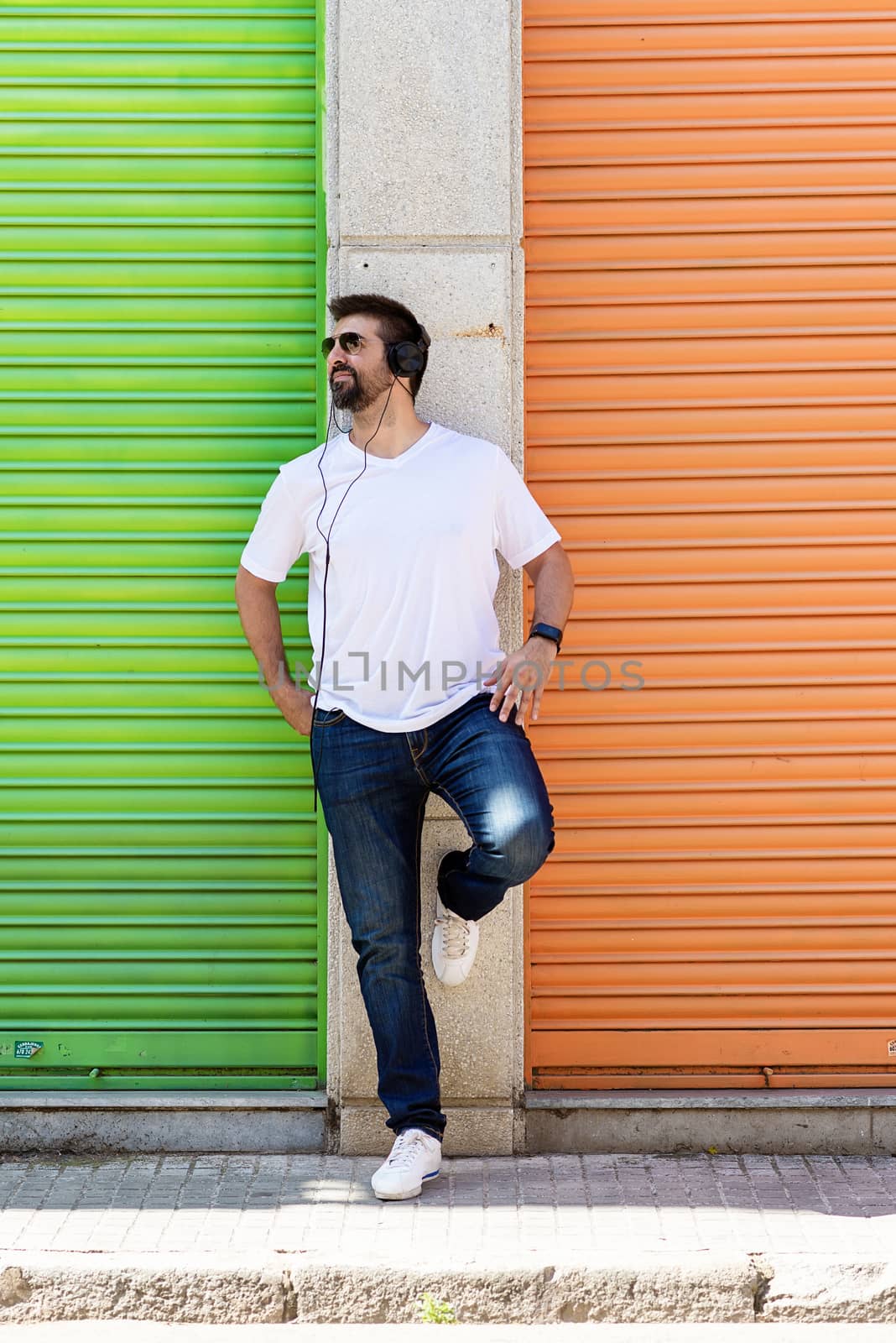 Cool trendy funny beard man in headphones listening music on colored background. by raferto1973