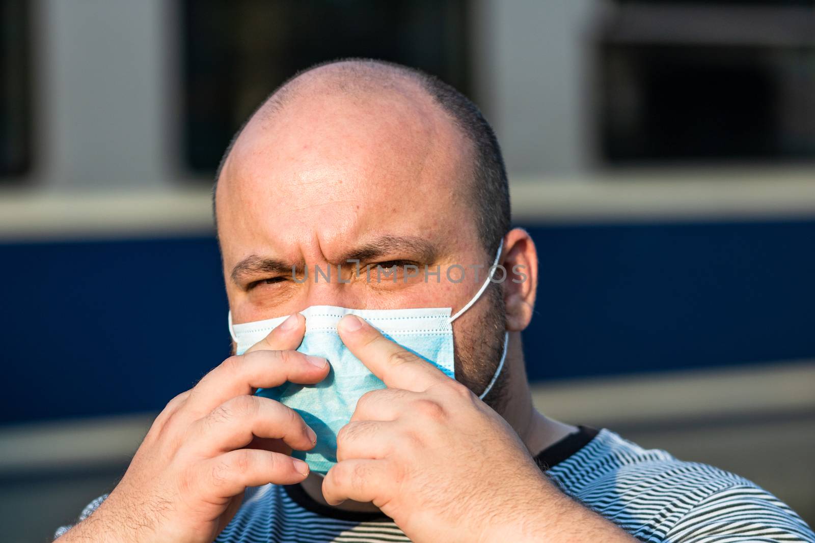 Young man with medical protective face mask illustrates pandemic by vladispas