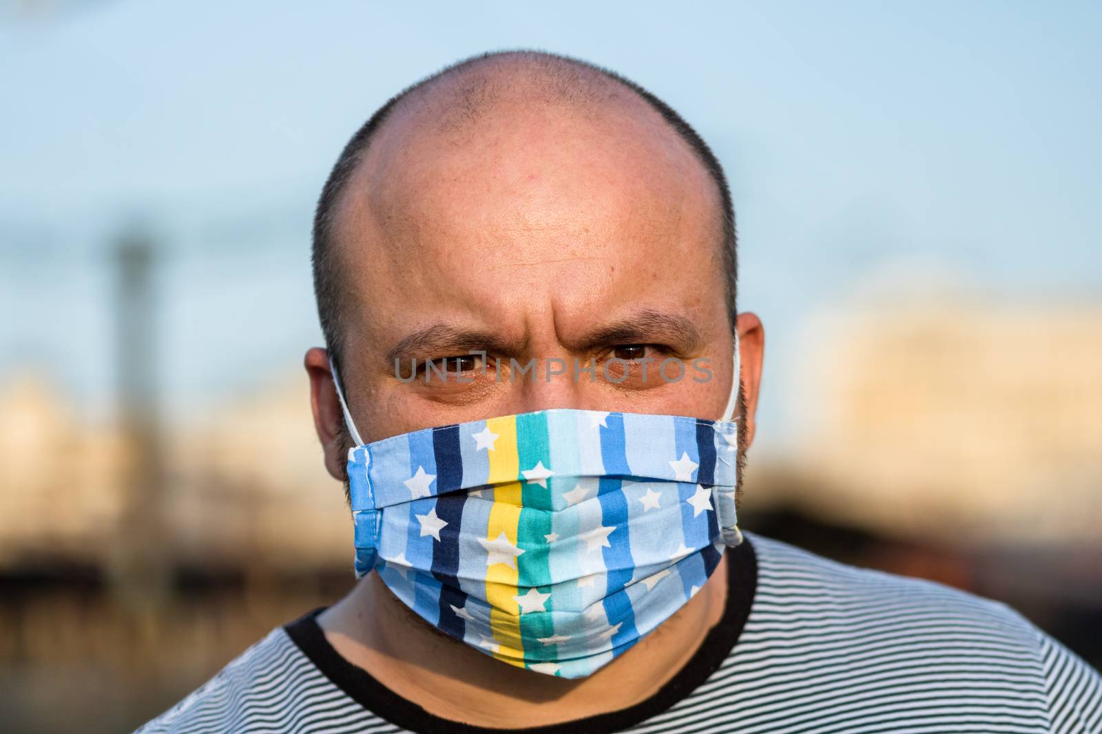 Young man with medical protective face mask illustrates pandemic by vladispas