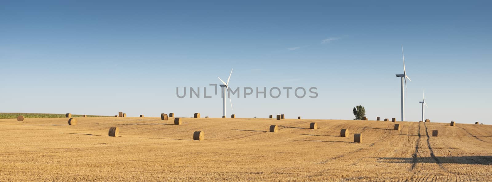 fields after harvest in the north of france near amiens with wind turbines in the background