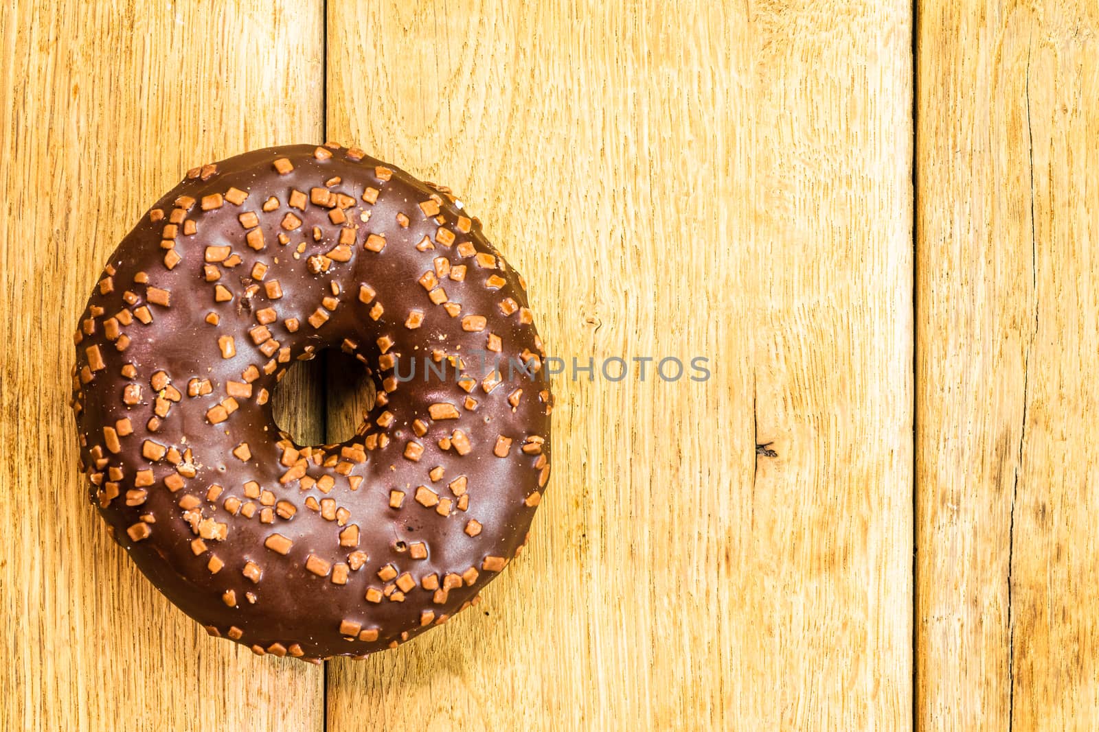 Colorful donuts on wooden table. Sweet icing sugar food with gla by vladispas