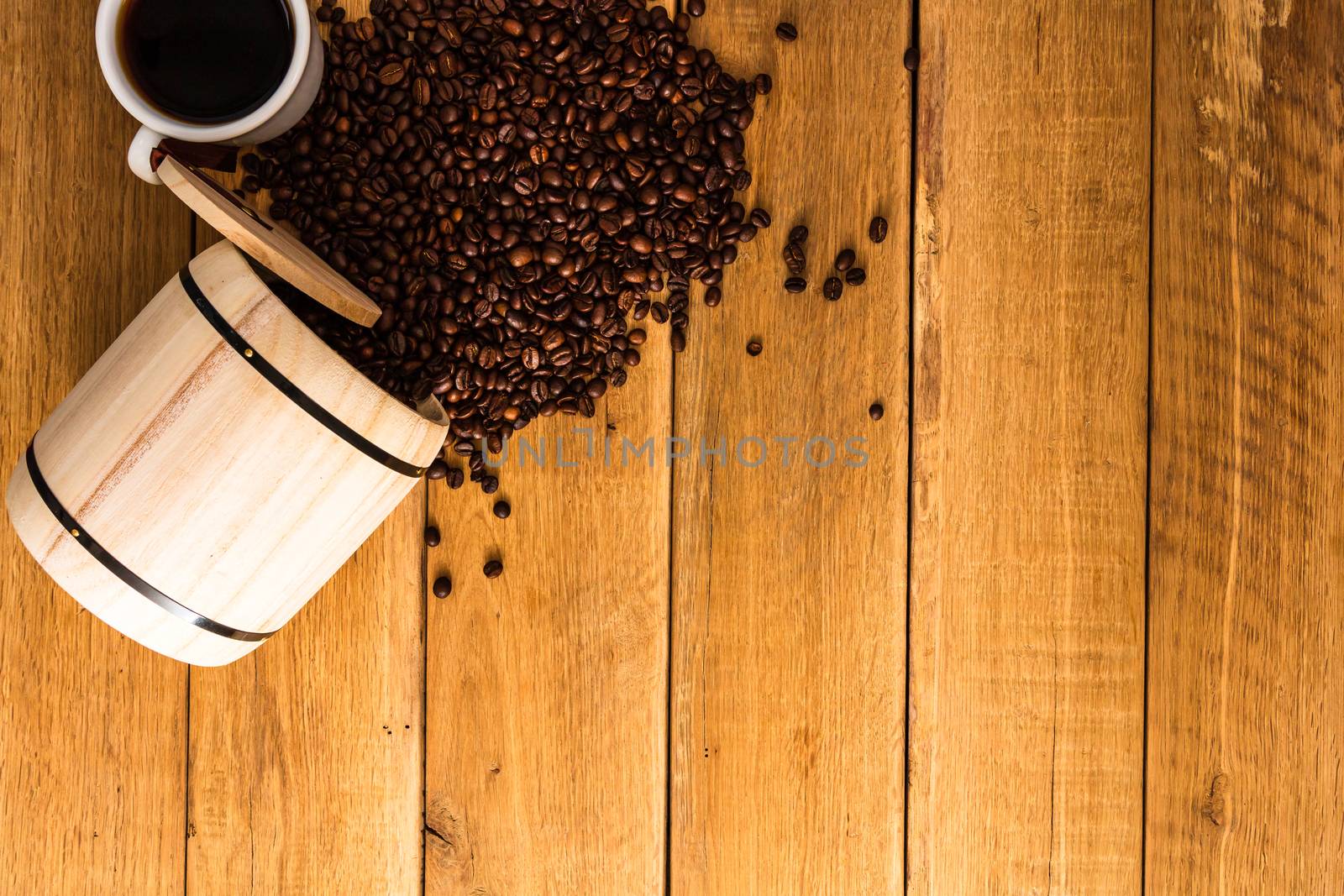 Cup of coffee, roasted coffee beans on wooden background, coffee wooden barrel top view, copy space for text, close up coffee photo