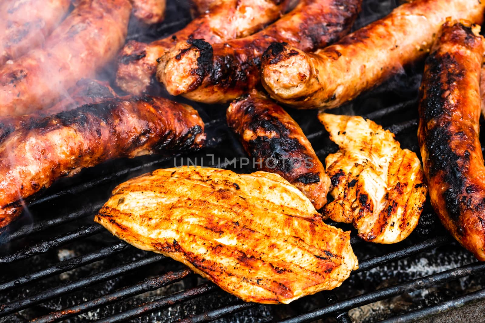 Close up on details of homemade chicken, pork steak and sausages by vladispas