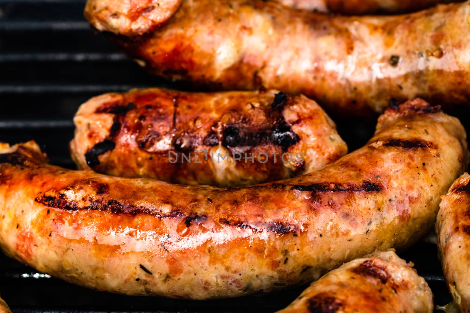 Close up on details of homemade sausages on barbecue grill. Barbecue, grill and food concept.