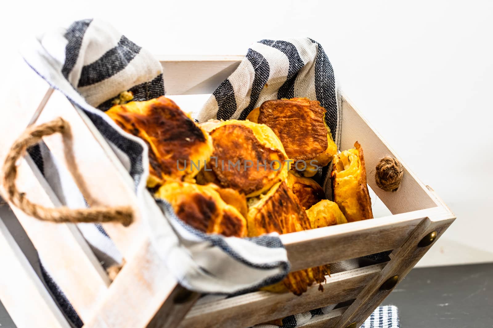 Freshly baked homemade ham and cheese puff pastry in a rustic crate.