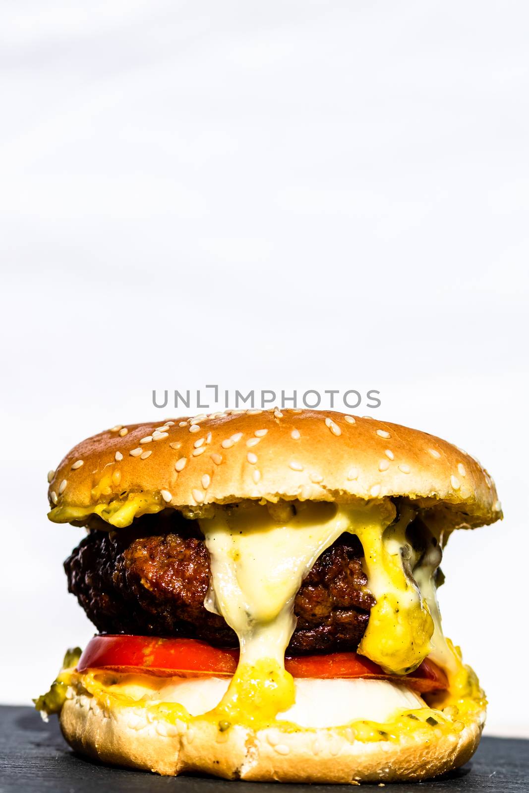 Beef cheeseburger with melting cheese. Tasty homemade cheeseburger isolated on white background.