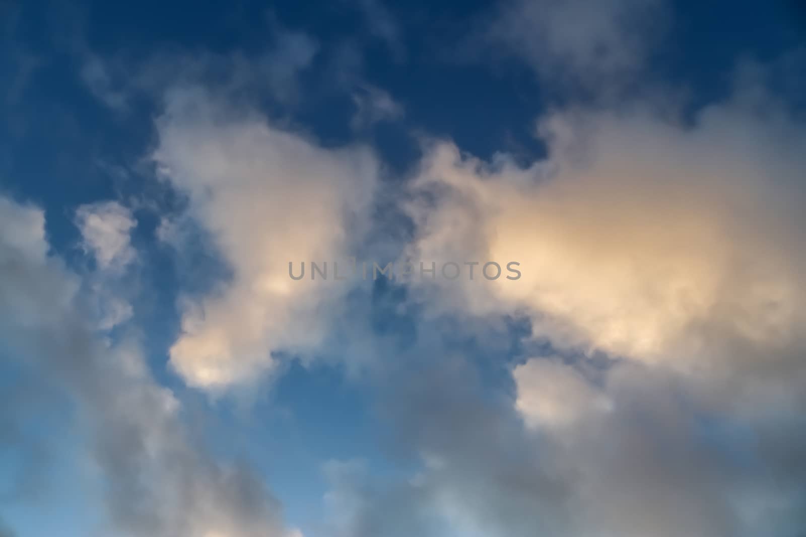 Beautiful panorama of orange and yellow clouds at sunrise and sunset in a blue sky