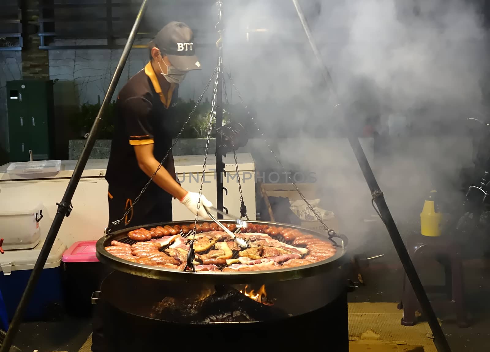 KAOHSIUNG, TAIWAN -- MARCH 2, 2018: An outdoor vendor at a night market grills fresh pork sausages and meat.