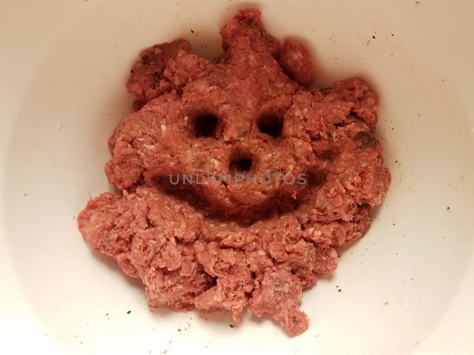 face with smile and eyes in raw beef in container by stockphotofan1