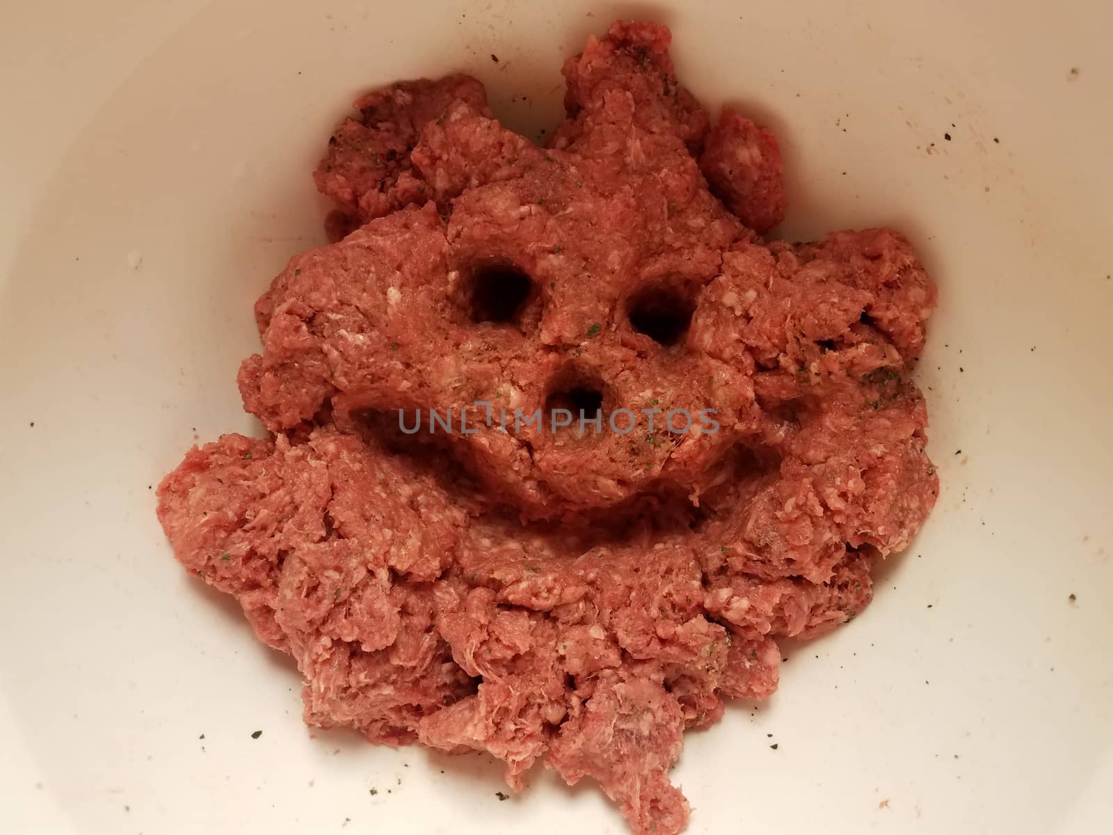 face with smile and eyes in raw pork in container by stockphotofan1