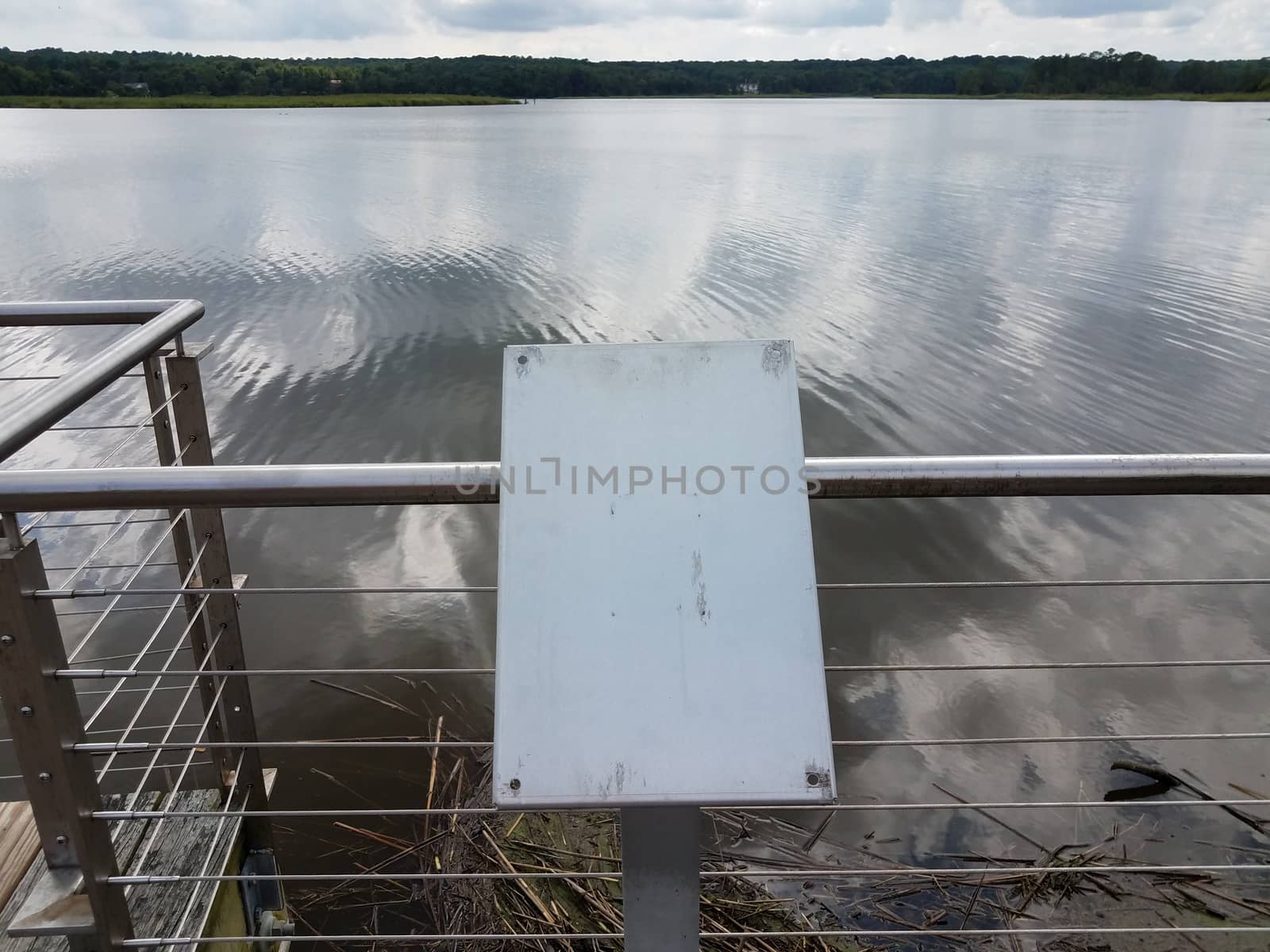 blank and worn metal plaque on railing with river water by stockphotofan1