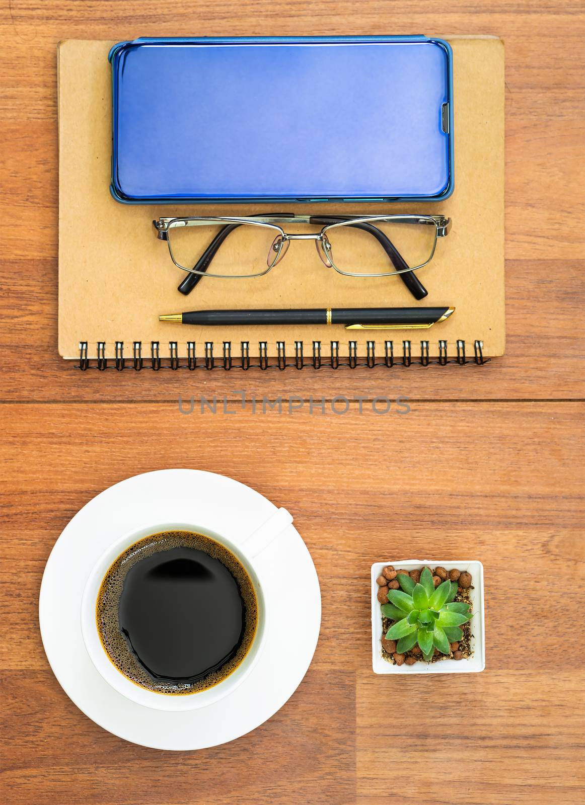 Top view image of coffee cup and cellphone on wooden table by stoonn