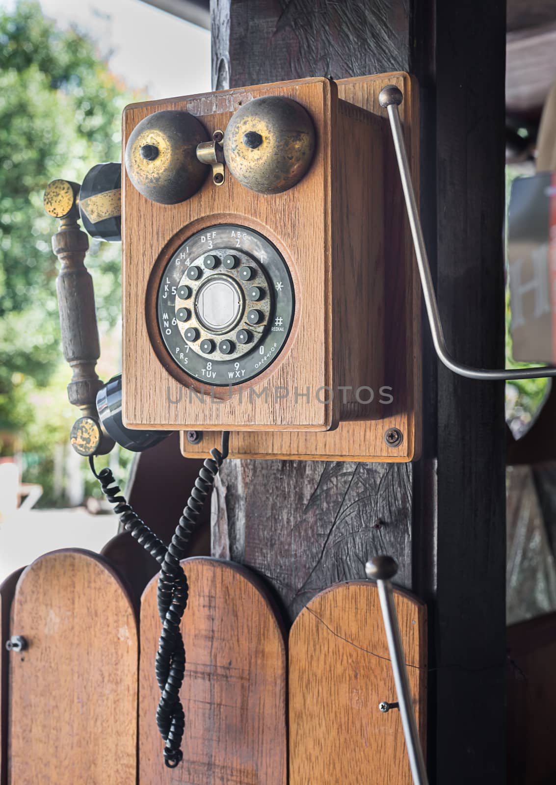 Retro vintage telephone hang on wooden pole in vintage style