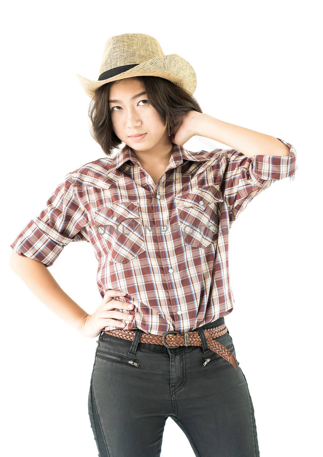 Young woman in a cowboy hat and plaid shirt with hand on her hat by stoonn