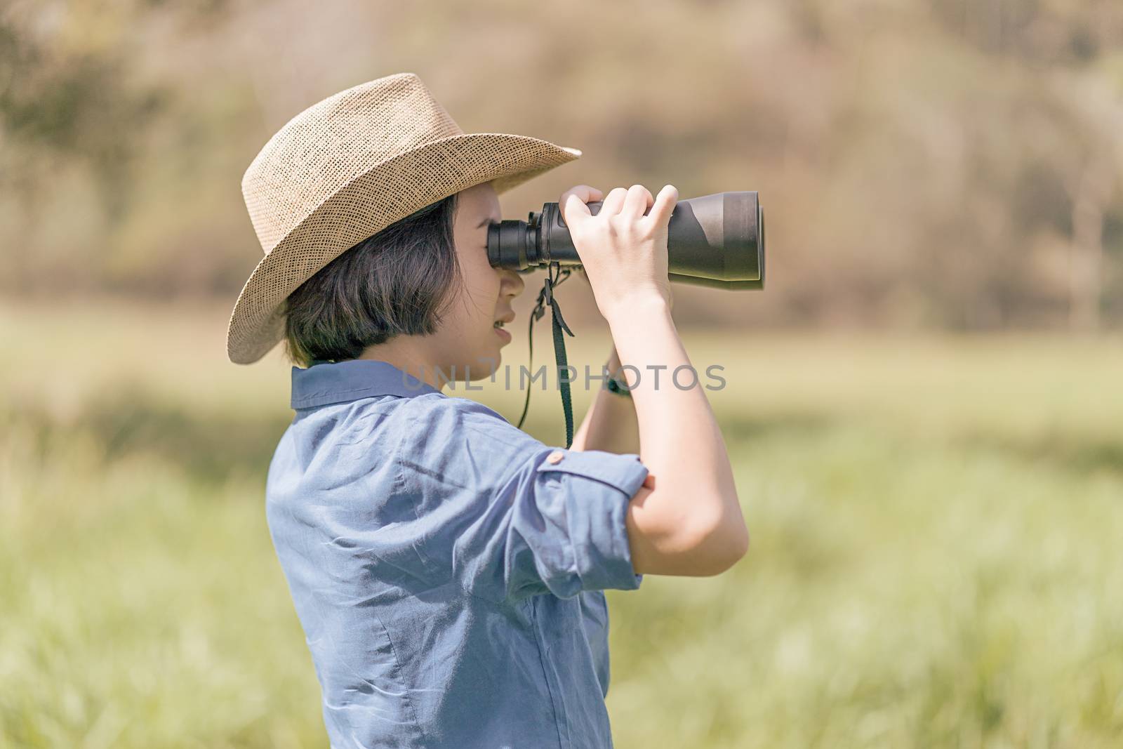 Woman wear hat and hold binocular in grass field by stoonn