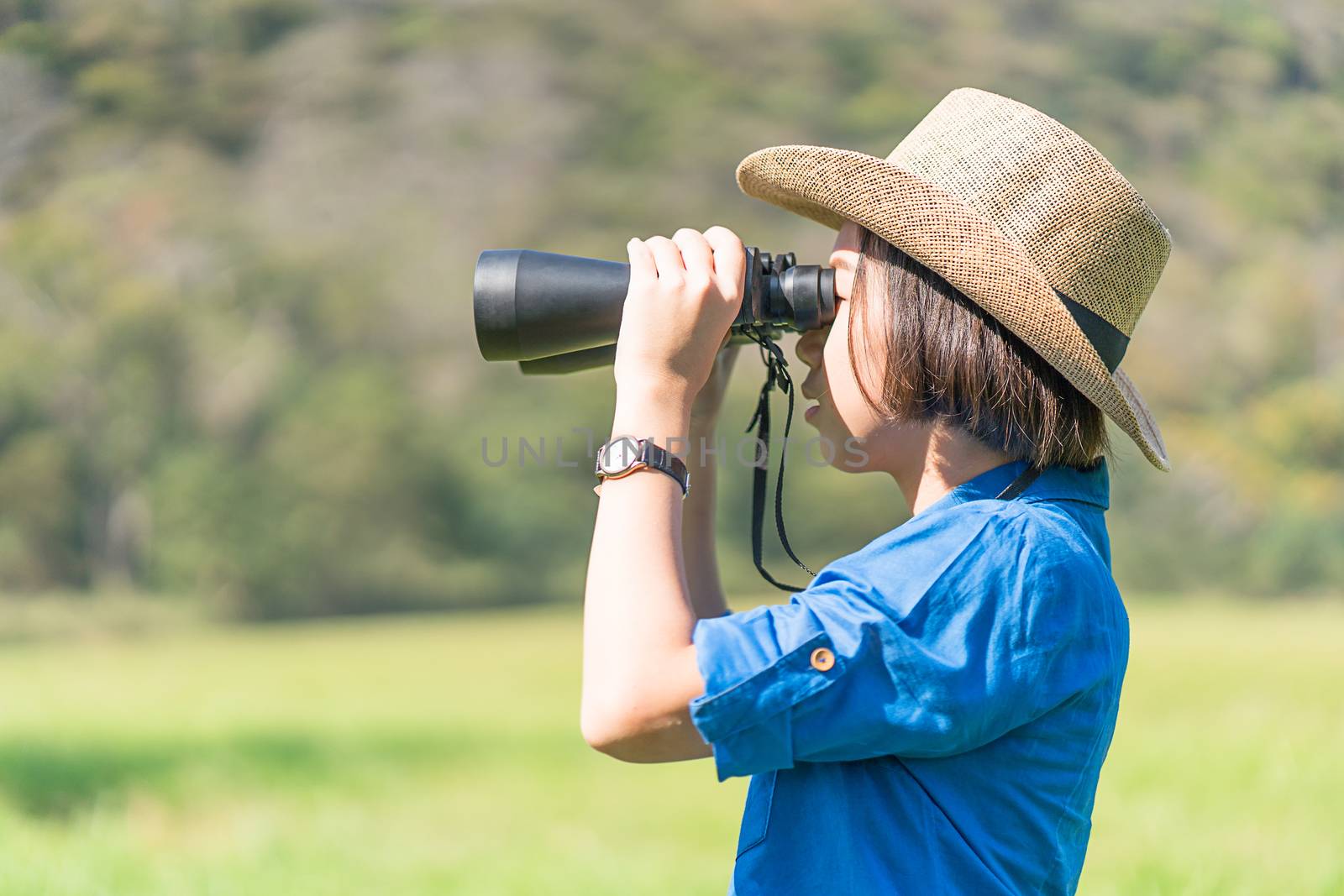 Woman wear hat and hold binocular in grass field by stoonn