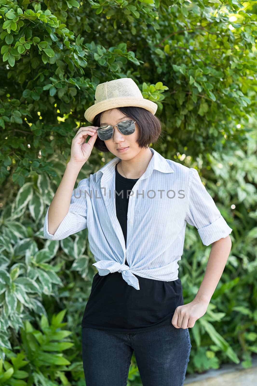 Beautiful and young women with short hair wearing hat in park