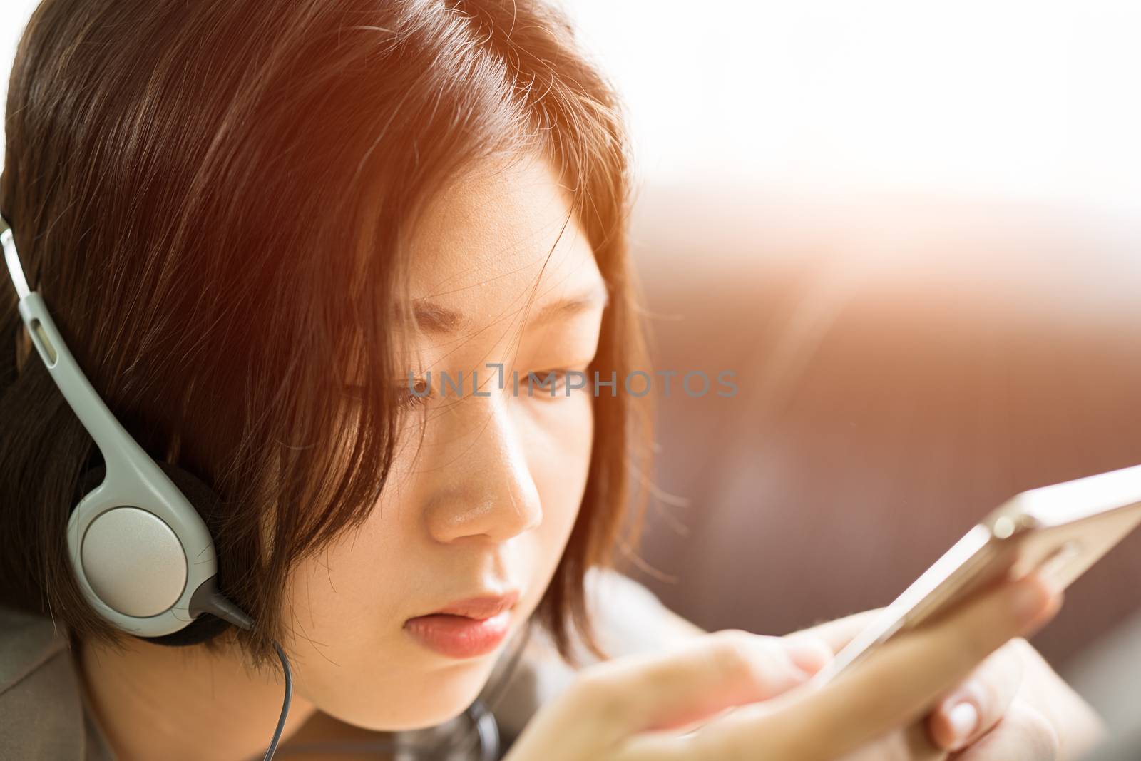 Young woman listening music from mobile phone by stoonn
