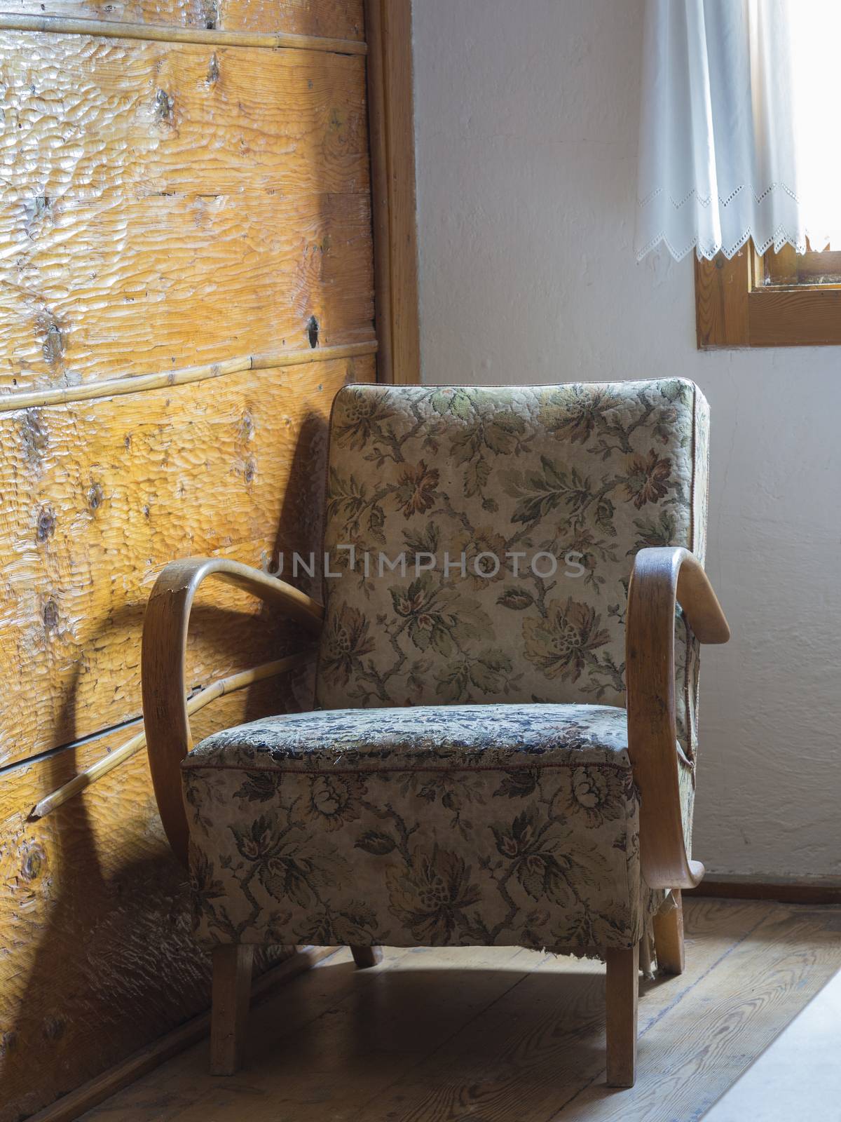 old upholstered wooden armchair with flower pattern under window by Henkeova