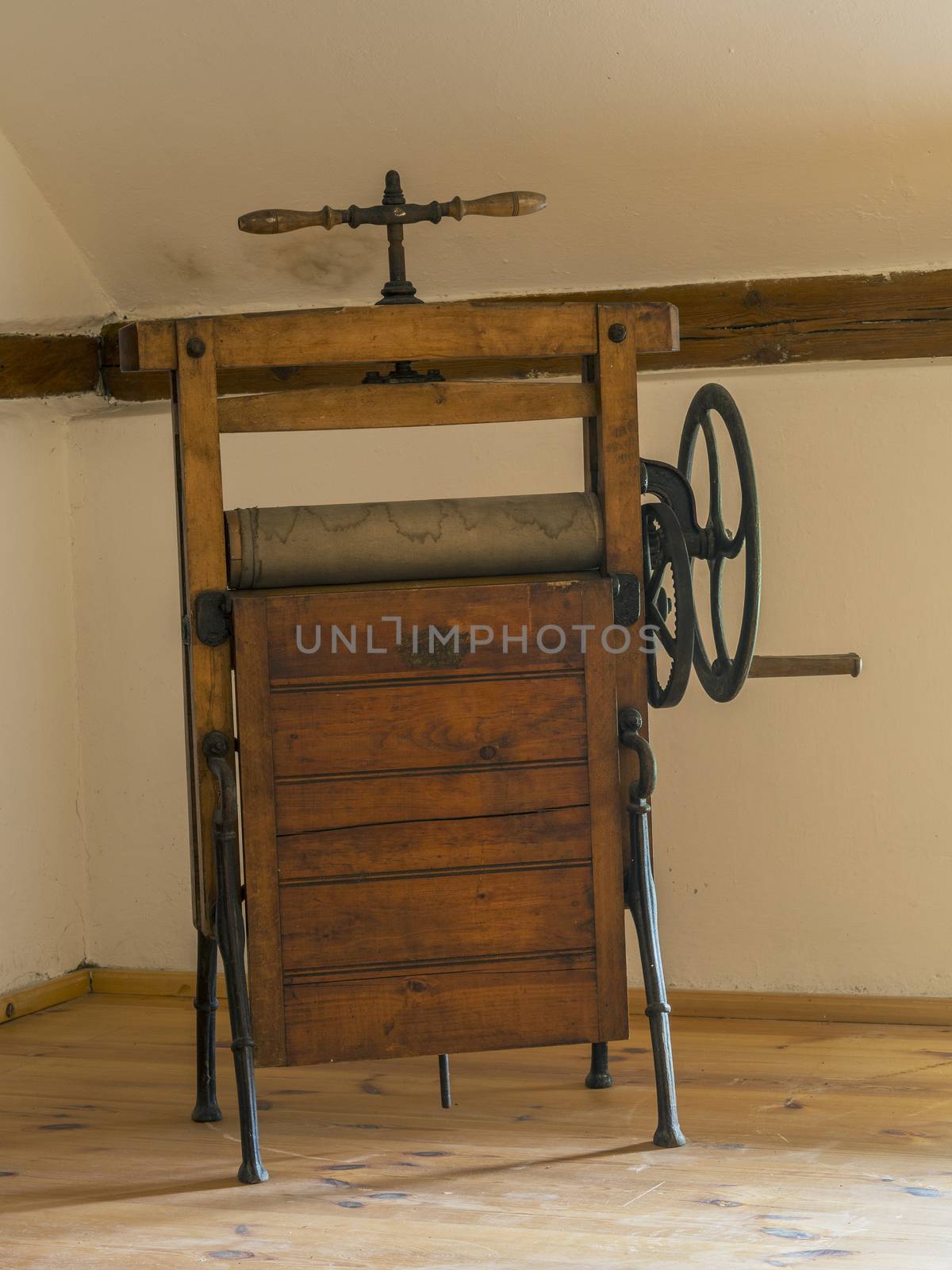 old antique wooden mangle rotary iron in attic room