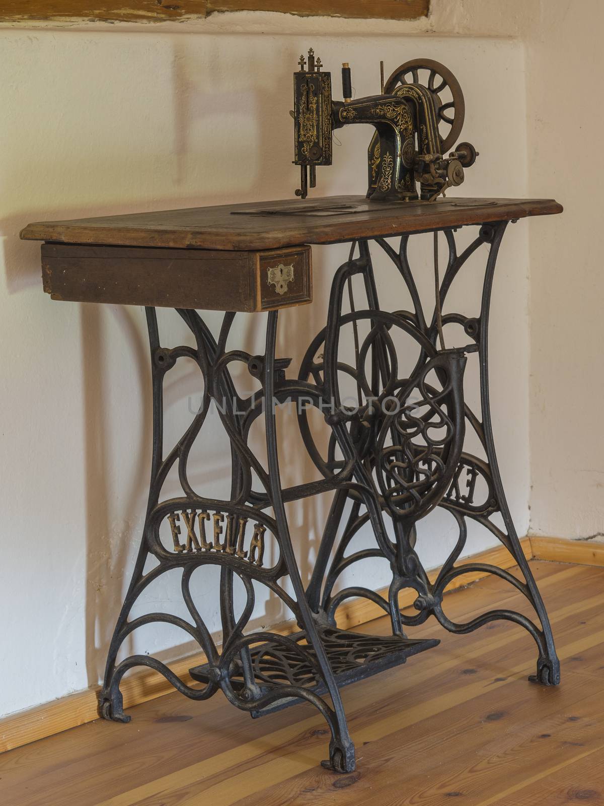 antique wooden iron sewing machine in attic room by Henkeova