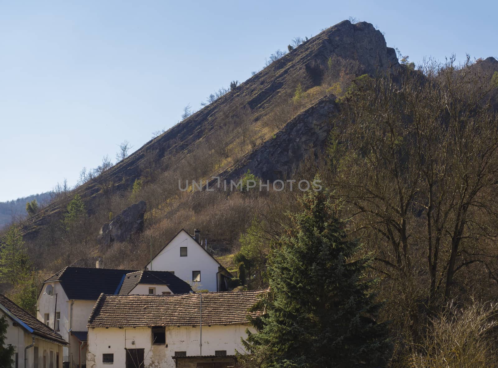 View on village with rock cliff Svaty Jan pod Skalou, Beroun, Central Bohemian Region, Czech Republic, Famous pilgrimage place, spring sunny day, blue sky by Henkeova