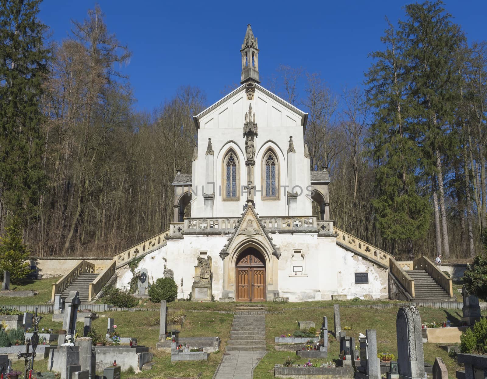 Saint Maximilian Chapel, baroque church with old cemetery in Saint John under the Cliff, Svaty Jan pod Skalou, Czech Republic, spring sunny day, blue sky.