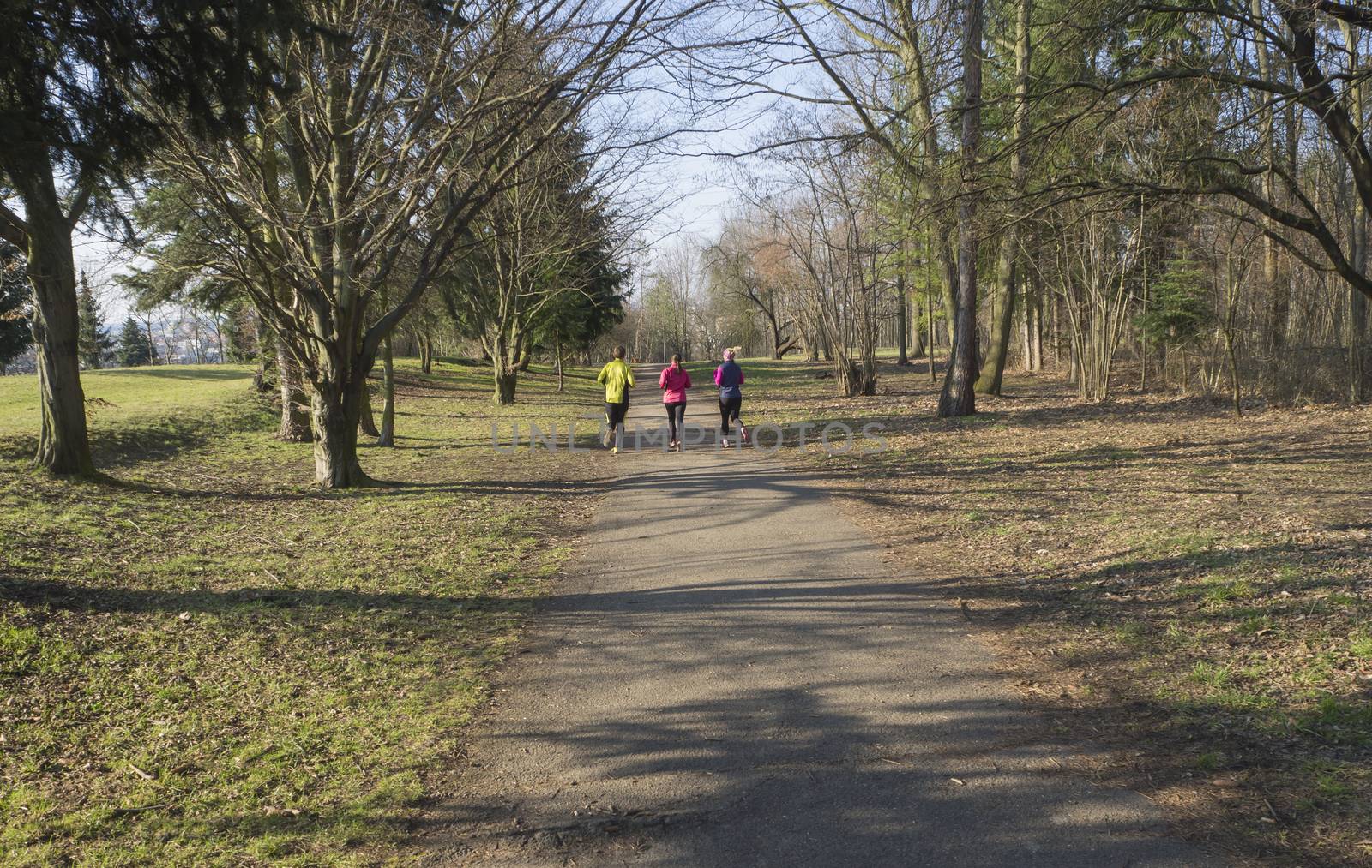 three people , young women and men running or jogging on publick by Henkeova