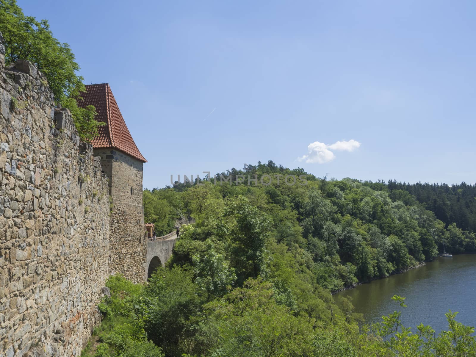 view from rampart of medieval castle Zvikov (Klingenberg), wall with tower, vltava river, spring green trees and blue sky, Czech Republic
