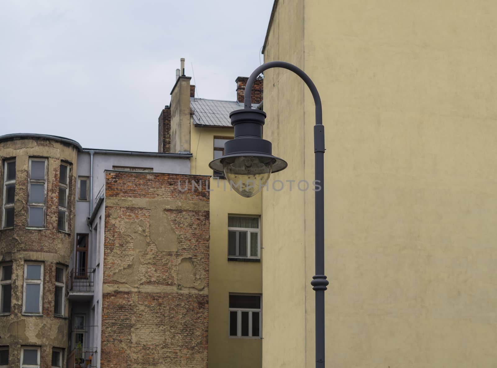 iron street lamp on industrial old cracked houses background