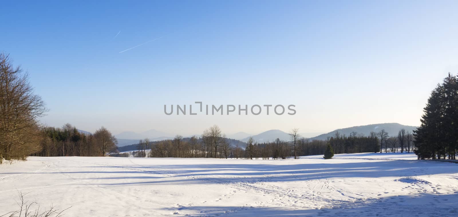winter field and forest countryside snow covered panoramic landscape with trees, hill in luzicke hory mountain by Henkeova