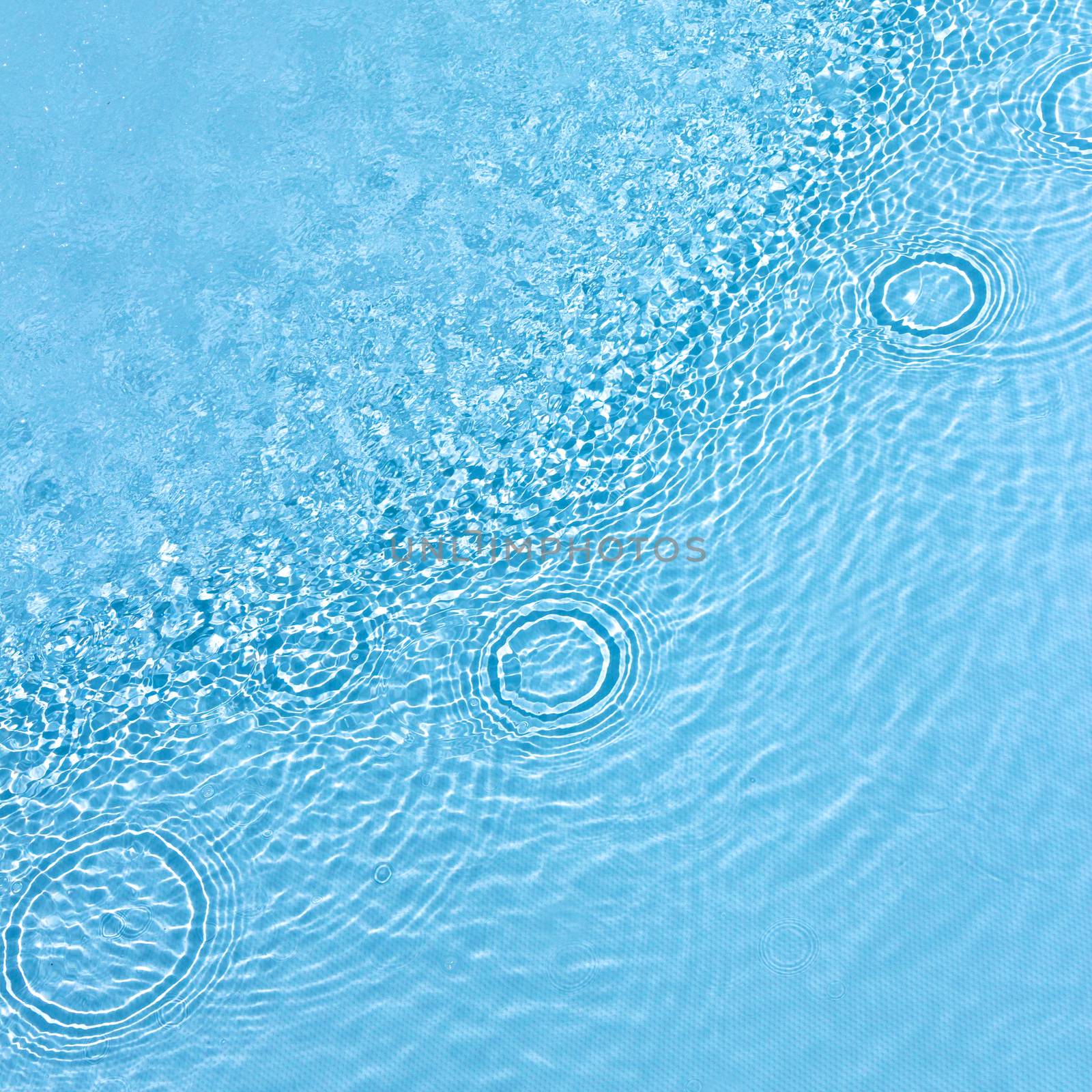 Water surface in the pool with raindrops