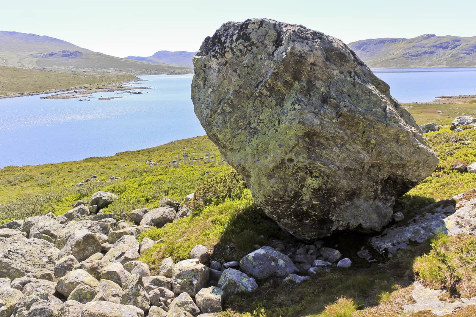 Huge boulder, big rock by the beautiful Vavatn lake in the mountains in Hemsedal, Buskerud, Norway.