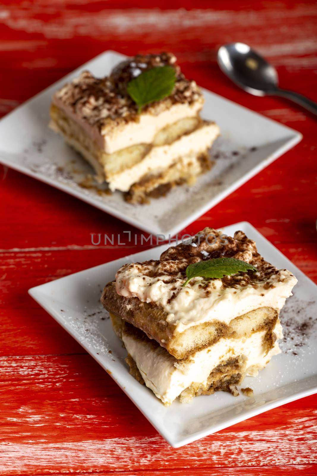 portion of tiramisu on a red table