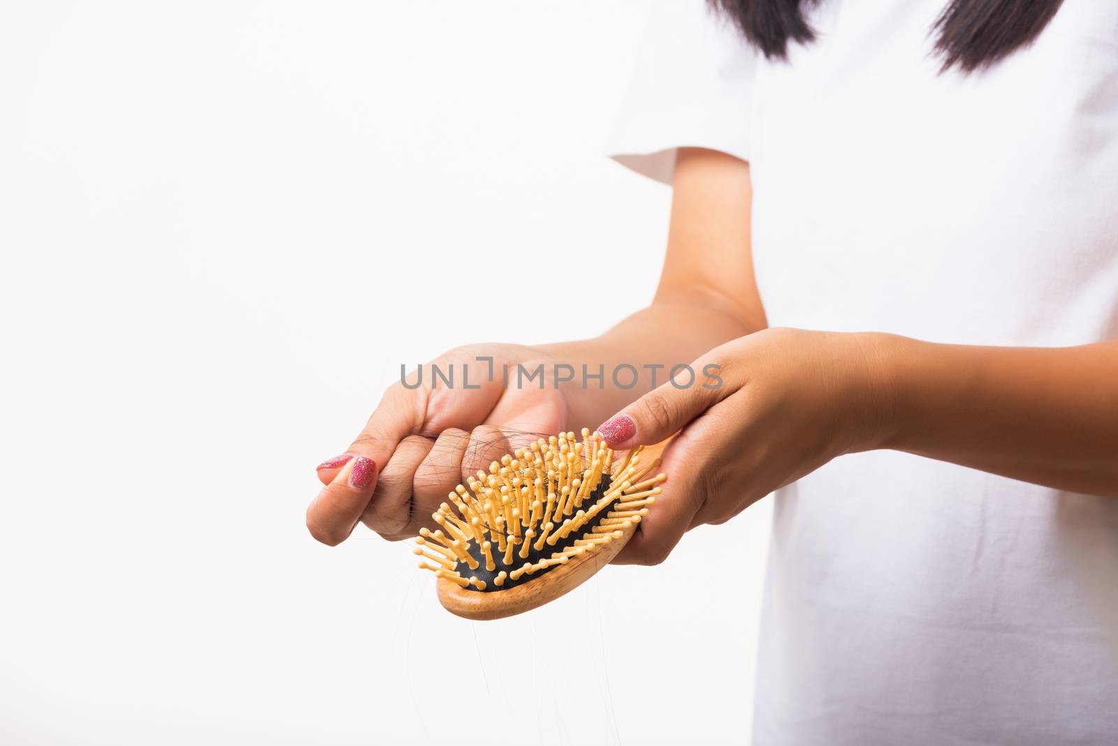 Asian woman unhappy weak hair problem her hold hairbrush with damaged long loss hair in the comb brush she pulls loss hair from the brush, isolated on white background, Medicine health care concept