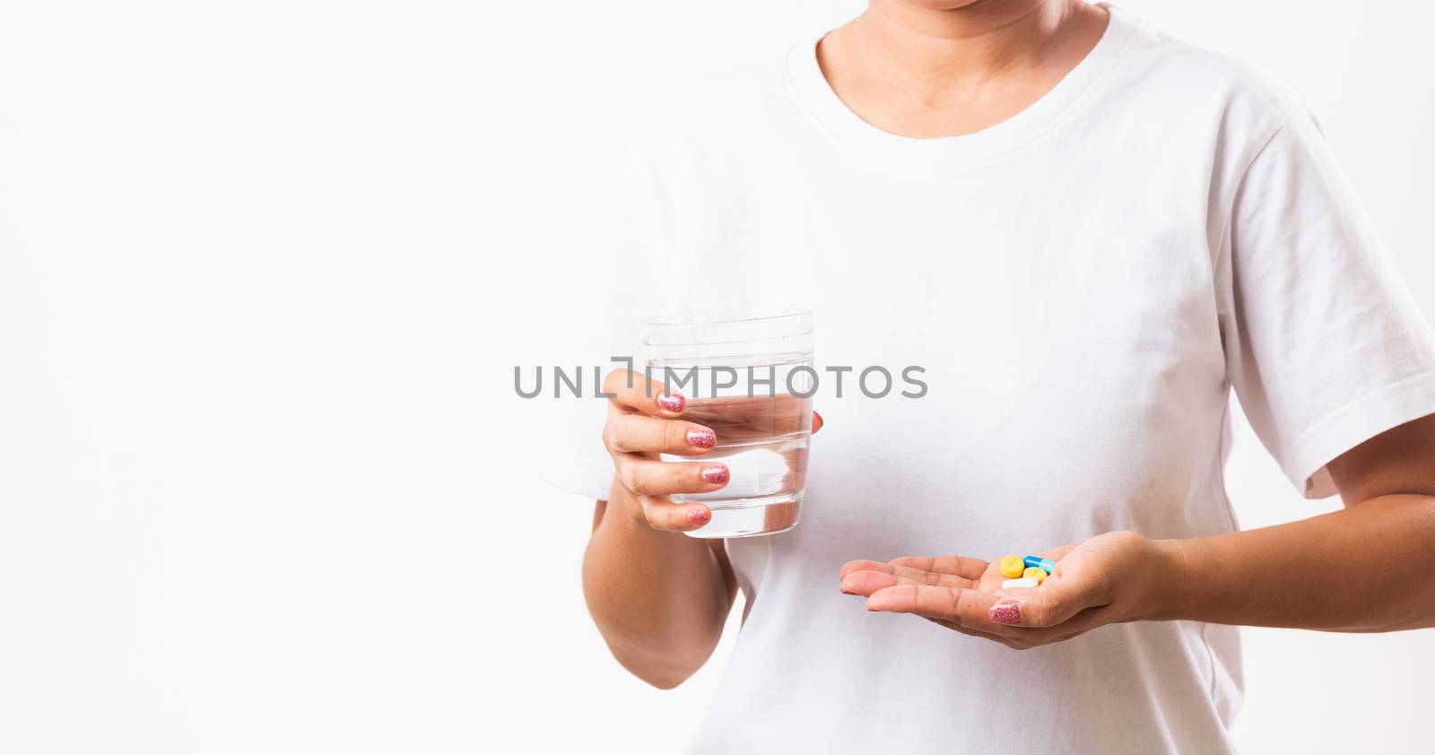 Closeup young Asian woman hold pill drugs in hand ready take medicines with a glass of water, studio shot isolated on white background, Healthcare and medical pharmacy concept