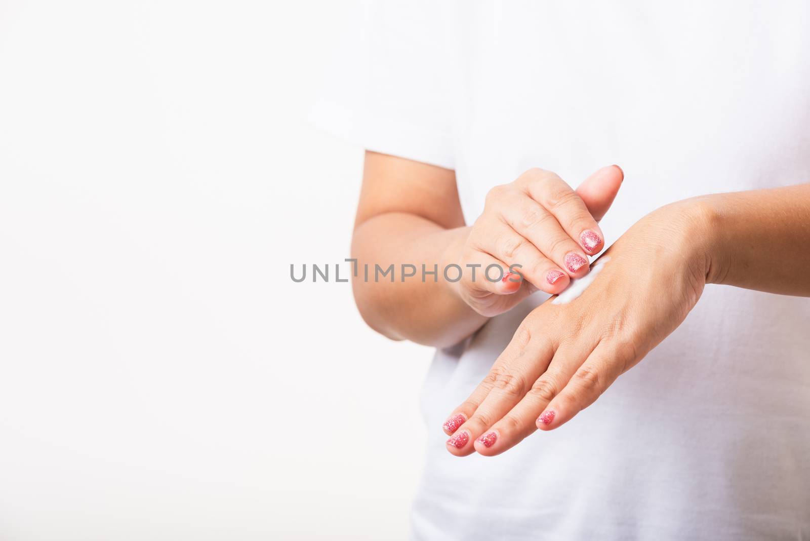 Woman applying lotion cosmetic moisturizer cream on her behind t by Sorapop