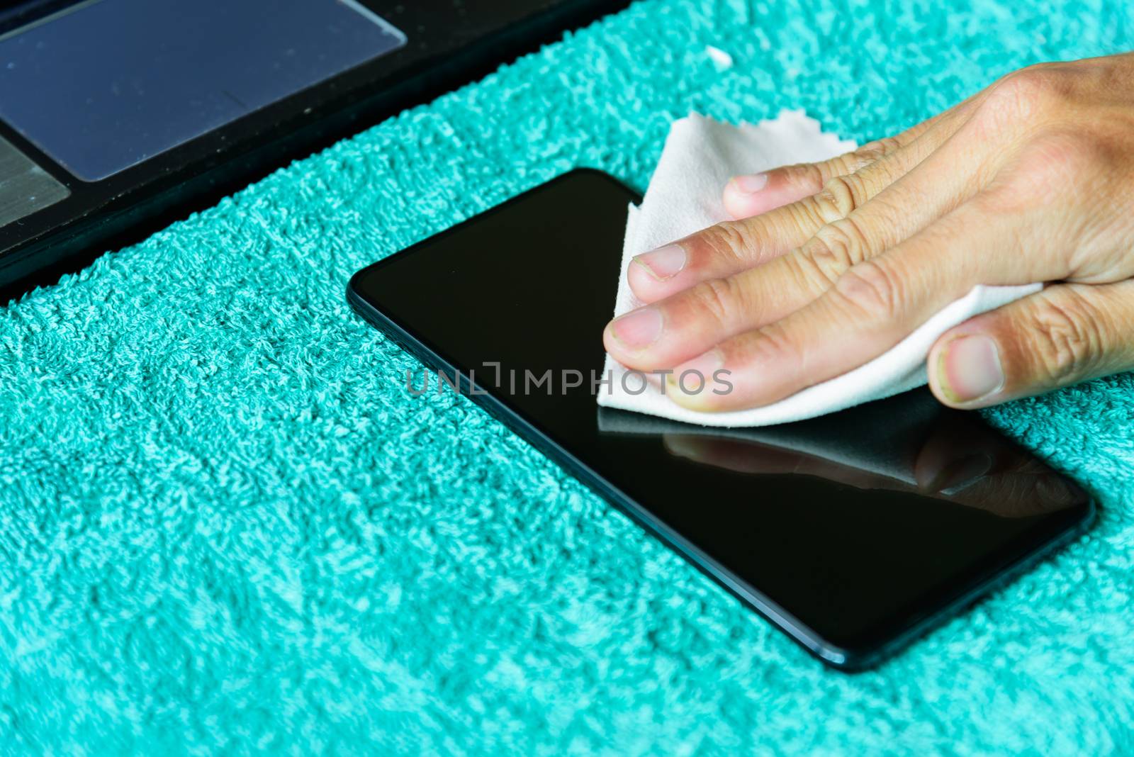 cleaning mobile phone screen by microfiber cloth. Before apply the smart phone screen protect flim by rukawajung