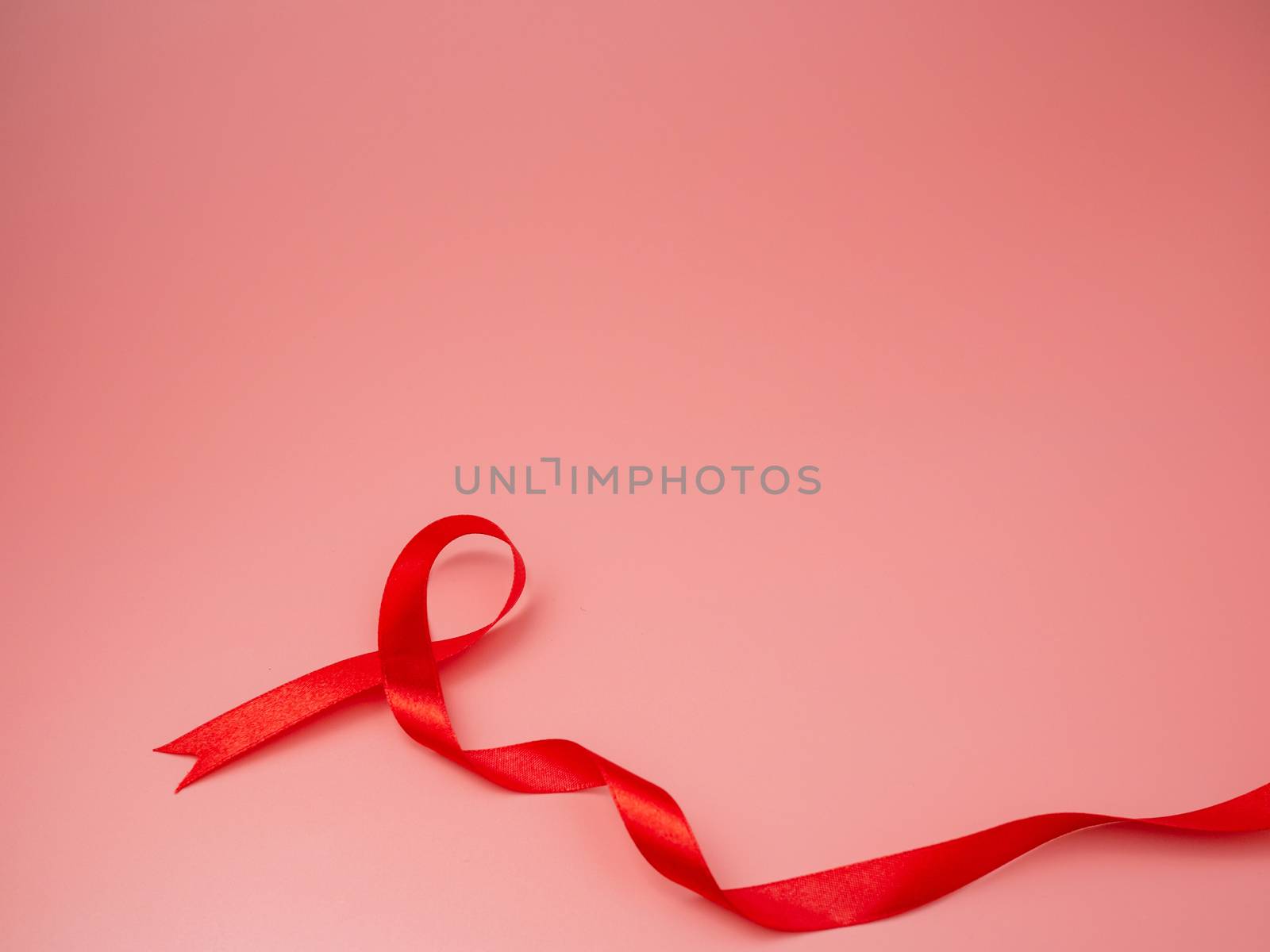 Symbol Red ribbon on pink background. by Unimages2527