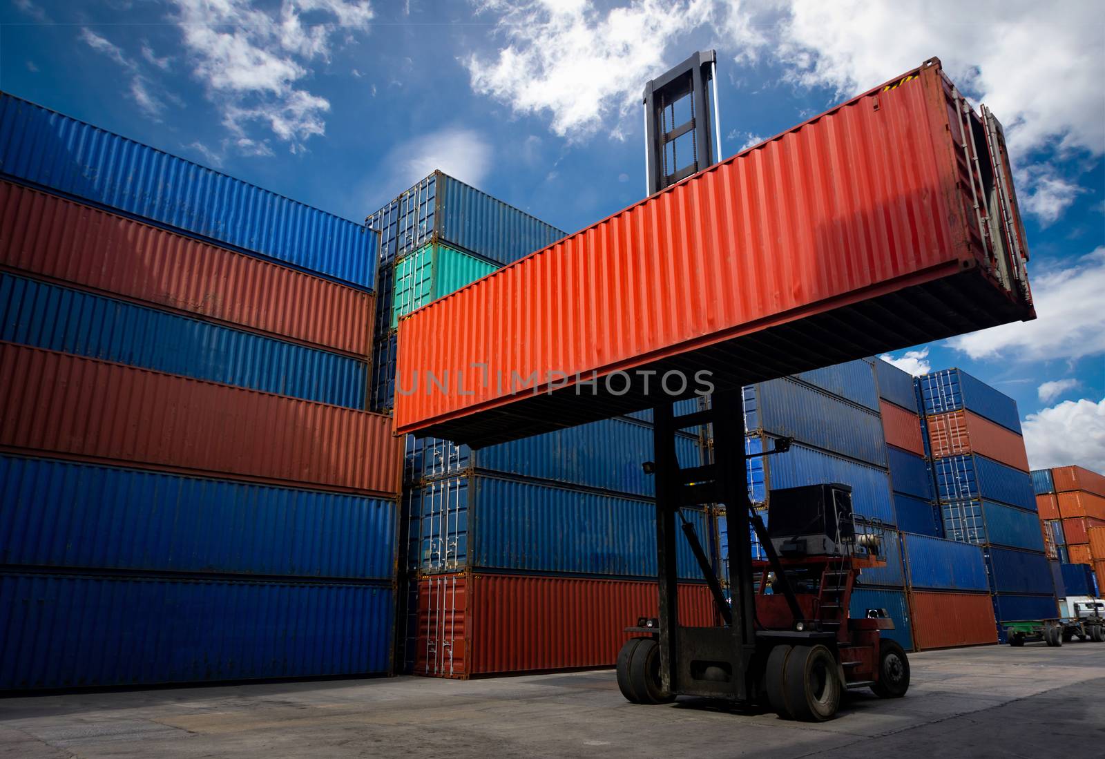 Forklift truck handling container box in shipping industry and cargo business at at warehouse yard.