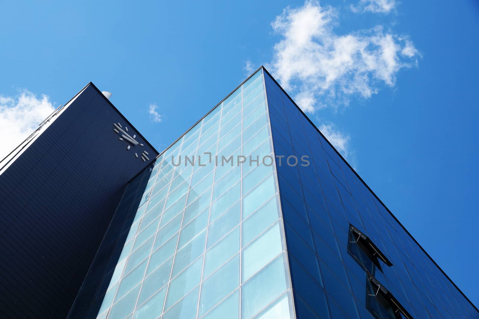 modern facade of a skyscraper against the backdrop of a sunny cloudy sky