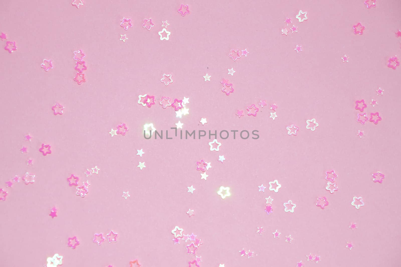 pink glittering stars on pink background close-up
