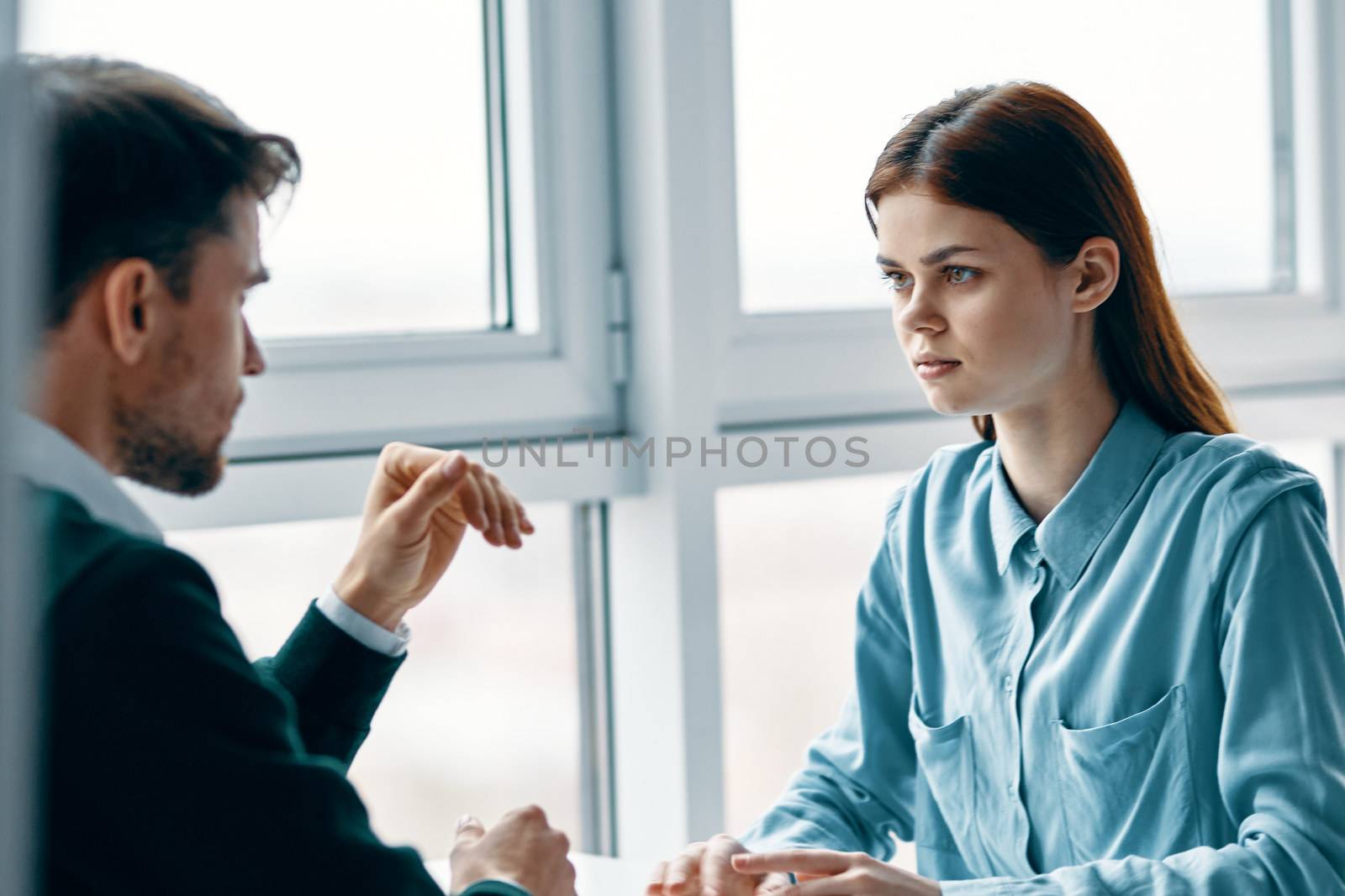 Beautiful young people at a table indoors near a cropped view window