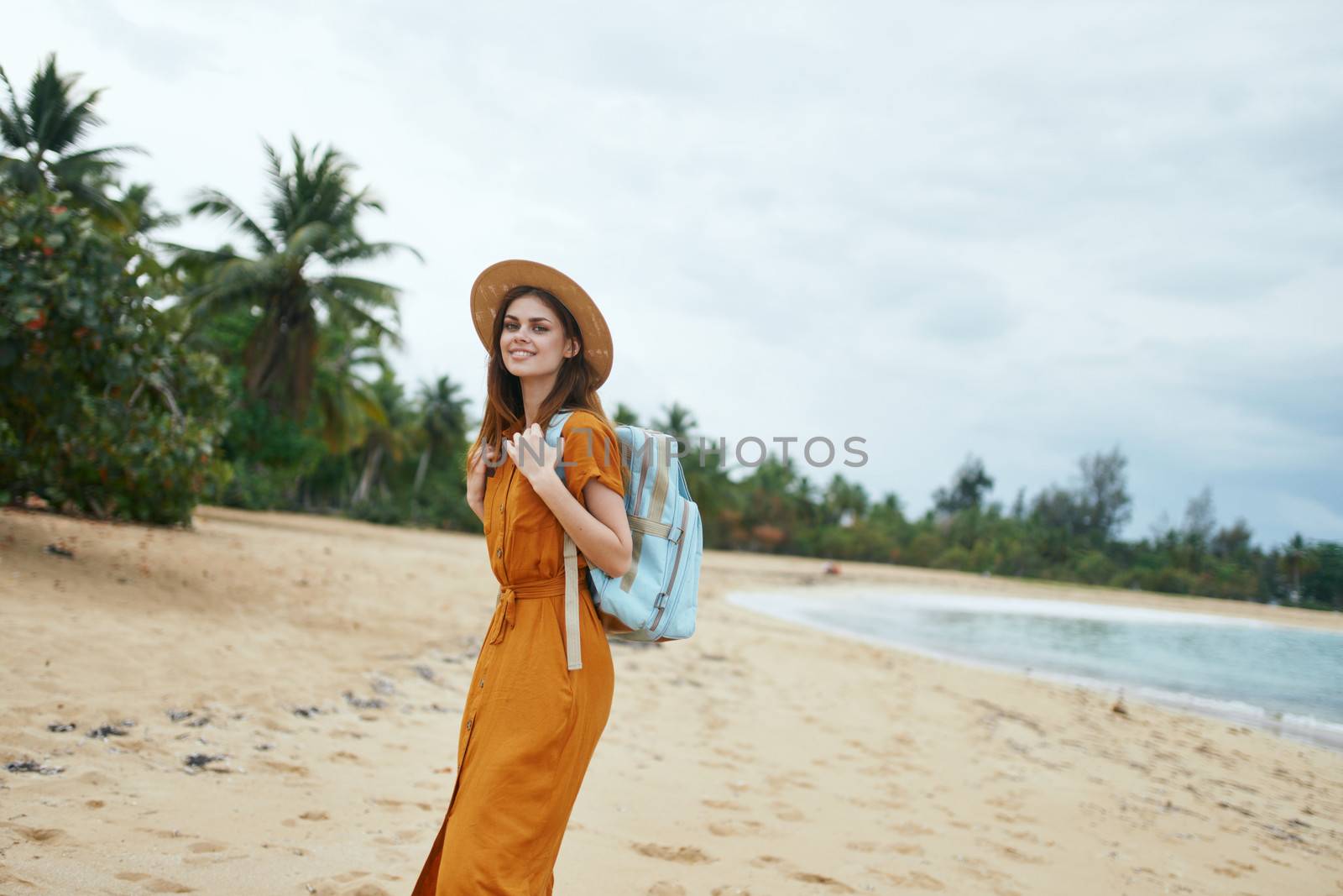 Beautiful woman in a sundress with a backpack on her back walk by SHOTPRIME