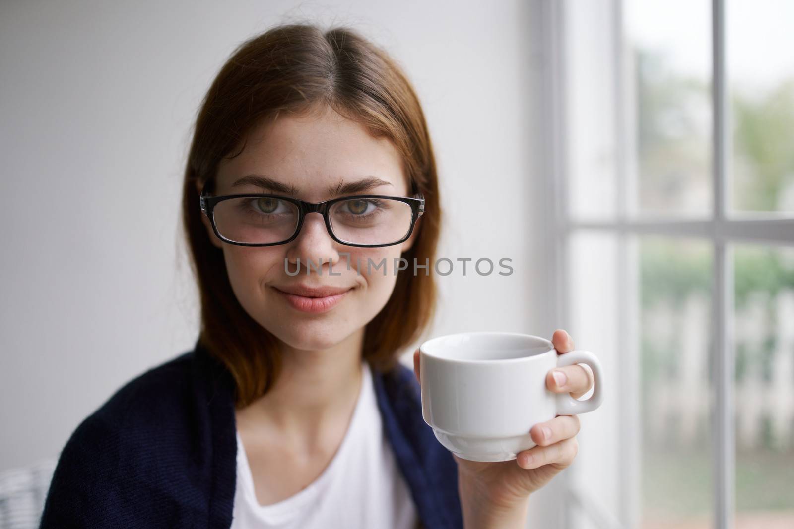 Cheerful woman at home with a cup of drink glasses lifestyle interior by SHOTPRIME