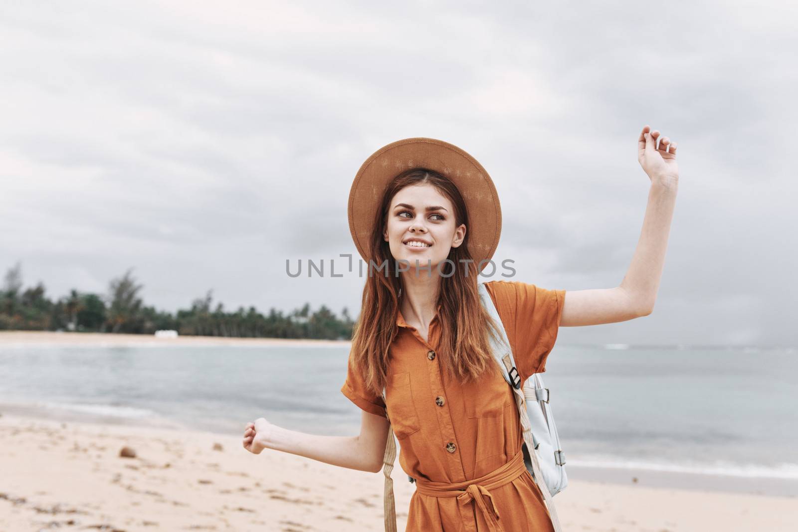 Happy woman in a hat travels on an island near the ocean